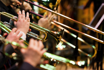 zbliżenie na dłonie trzymające blaszany instrument dęty